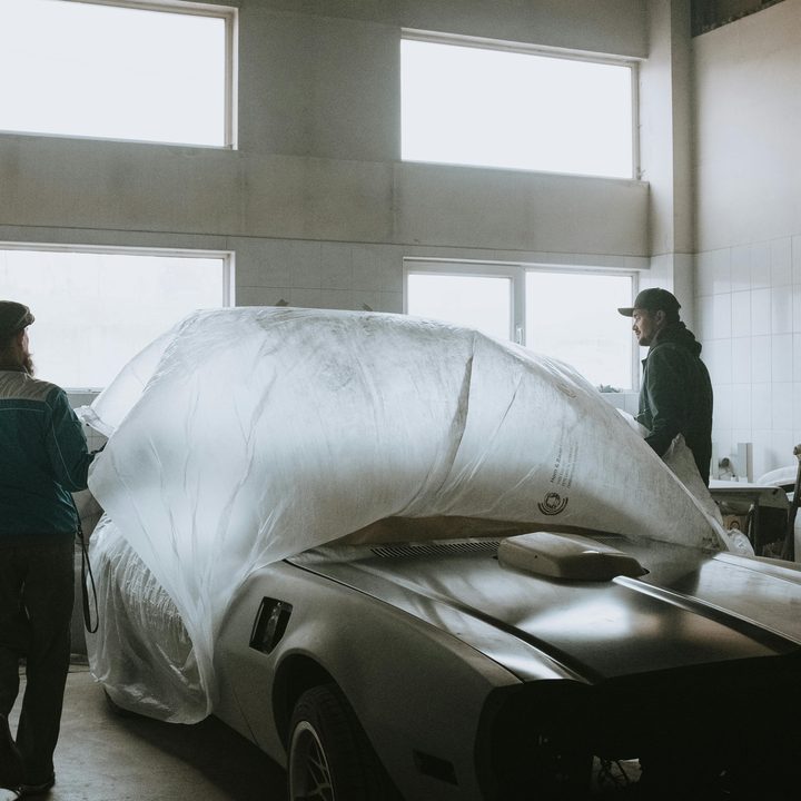 Funileiros preparando um carro para serviço de lataria